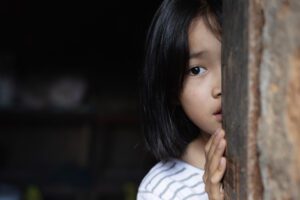 Trafficked girl looking out of a door