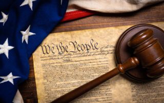 The United States Constitution with a US Flag and a gavel, showing its power