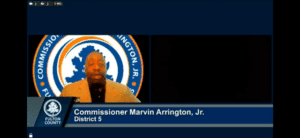 Marvin Arrington Jr. Fulton County Commissioner of District 5 with Fulton County logo behind her