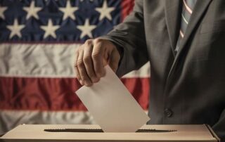 man in suit with ballot in hand putting in box to show election integrity