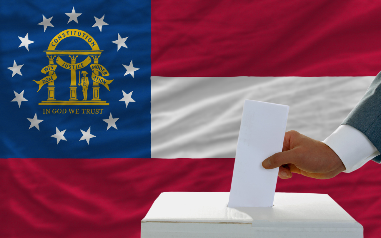 ballot box with ballot being placed in front of Georgia flag